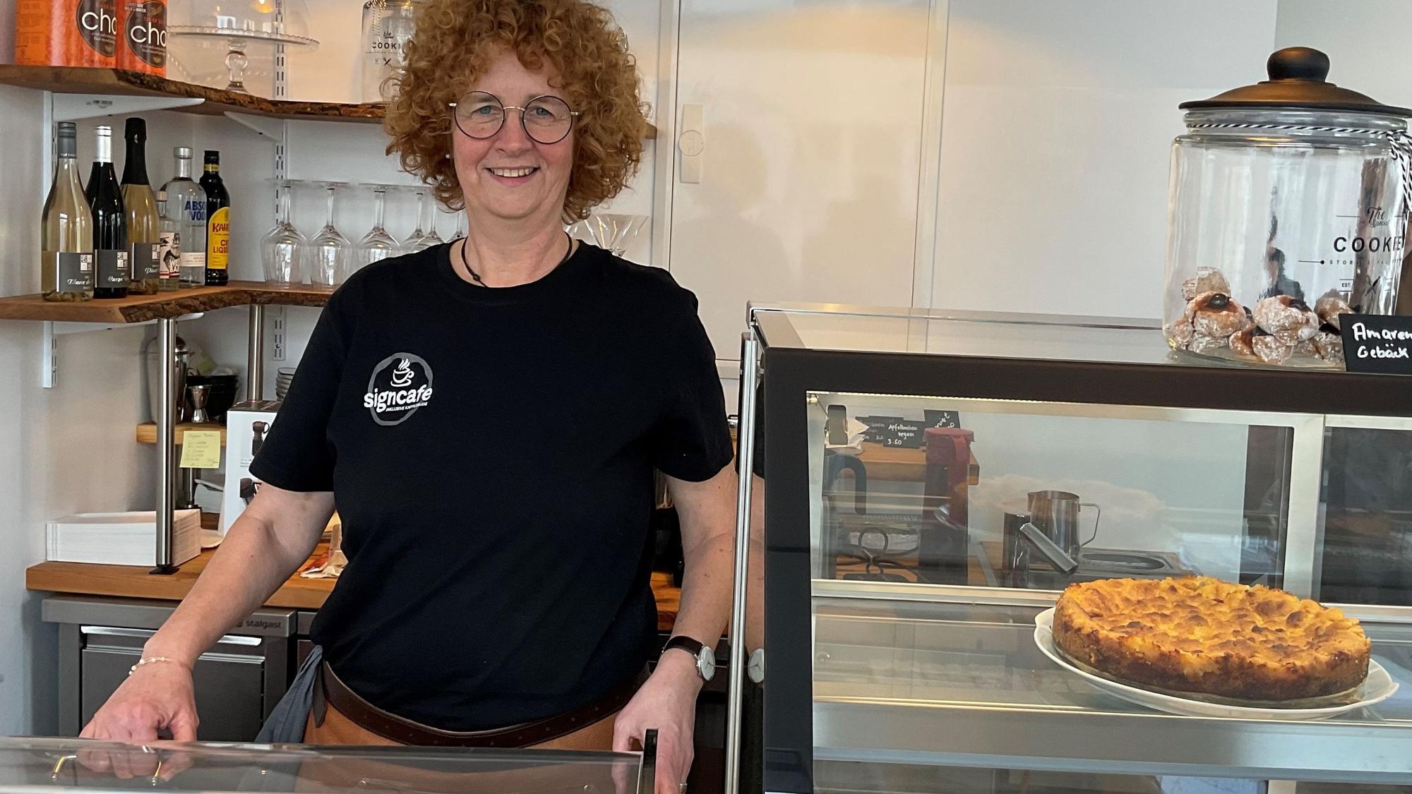 Lockige Frau hinter Kuchentheke