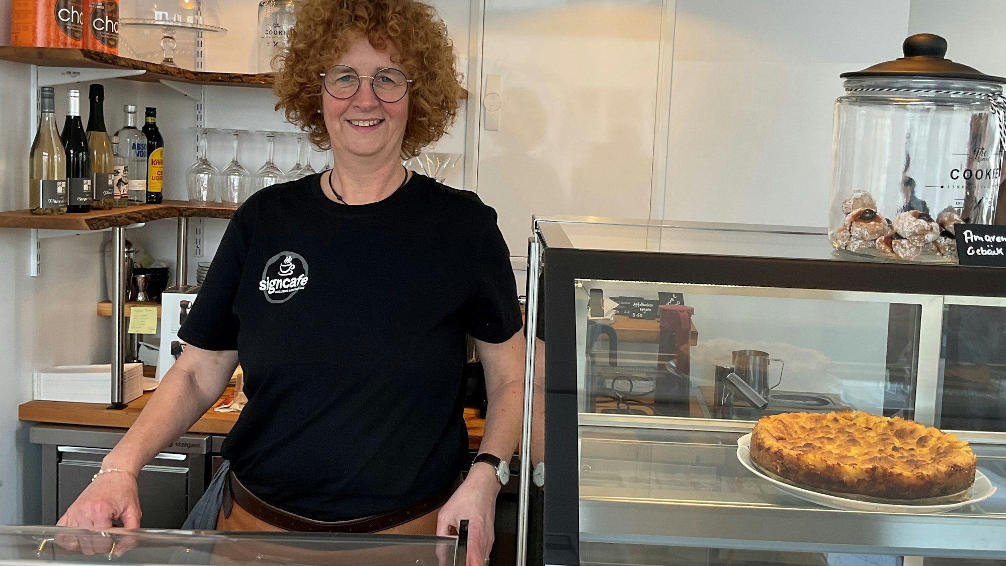 Lockige Frau hinter Kuchentheke