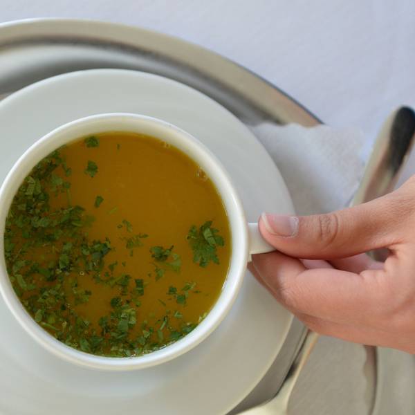 Eine Mitarbeiterin serviert in der Buchinger-Wilhelmi-Klinik in Überlingen eine Tasse Suppe. (Archivbild)
