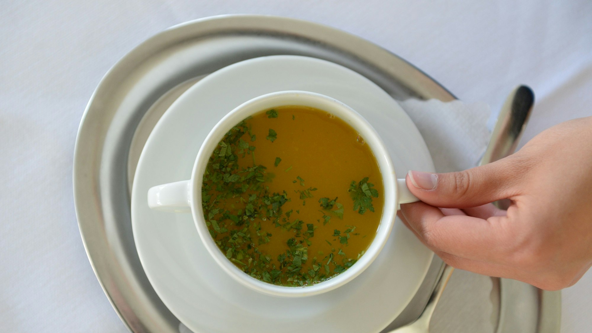 Eine Mitarbeiterin serviert in der Buchinger-Wilhelmi-Klinik in Überlingen eine Tasse Suppe. (Archivbild)
