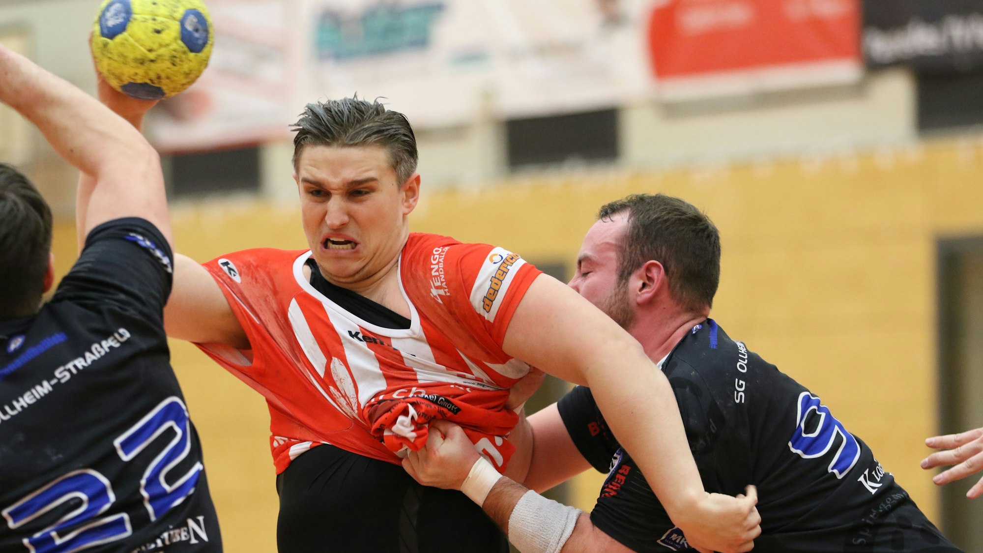 Das Bild zeigt Kazimierski in einem Zweikampf am Kreis. Sein Gegenspieler packt am Trikot ordentlich zu.