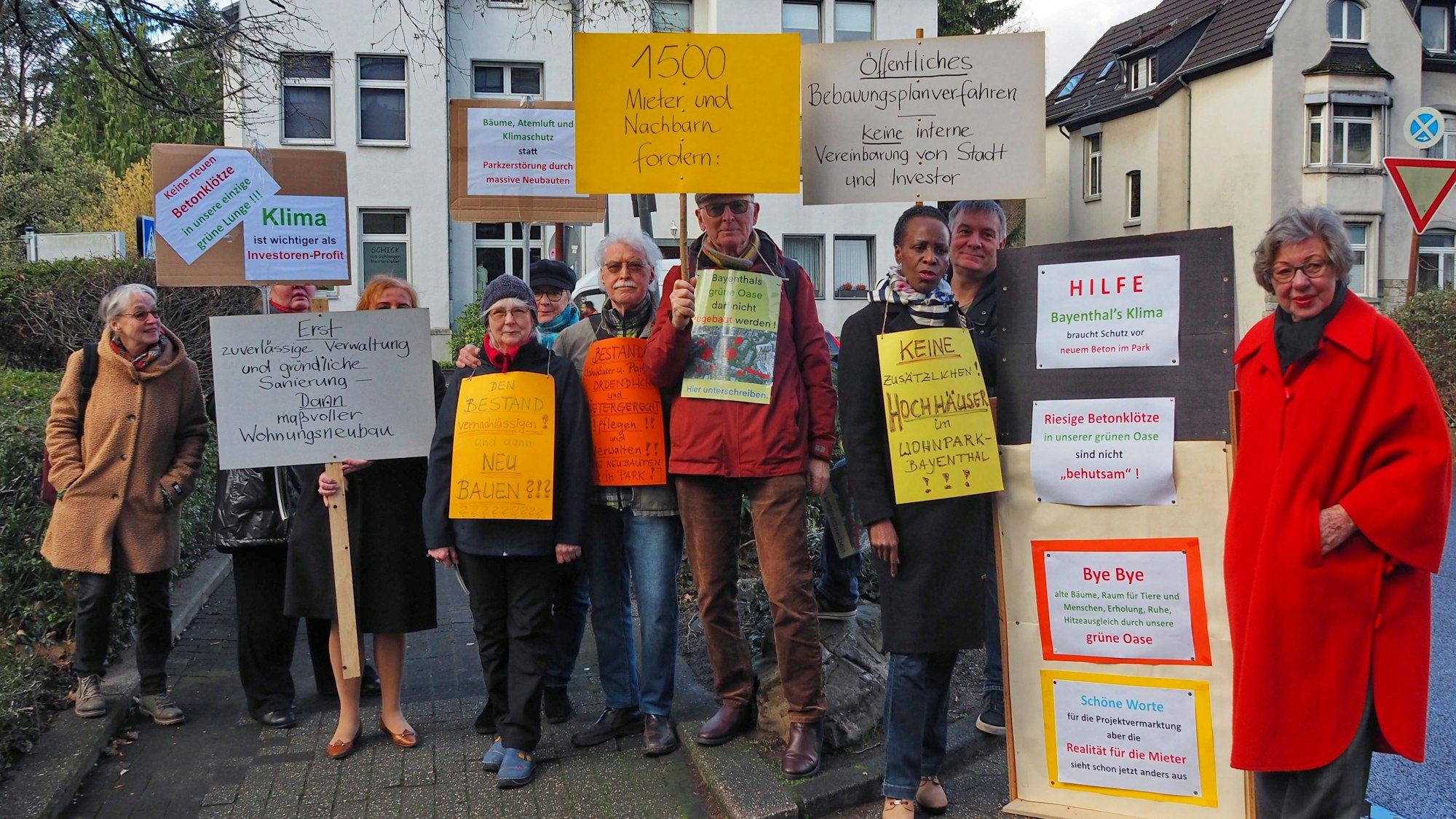 Eine Gruppe mit Protestplakaten steht nah beieinander.