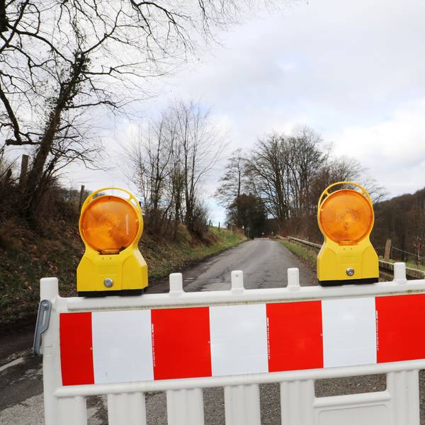 Eine Straße ist mit einer Bake und einem Durchfahrt-verboten-Schild gesperrt.