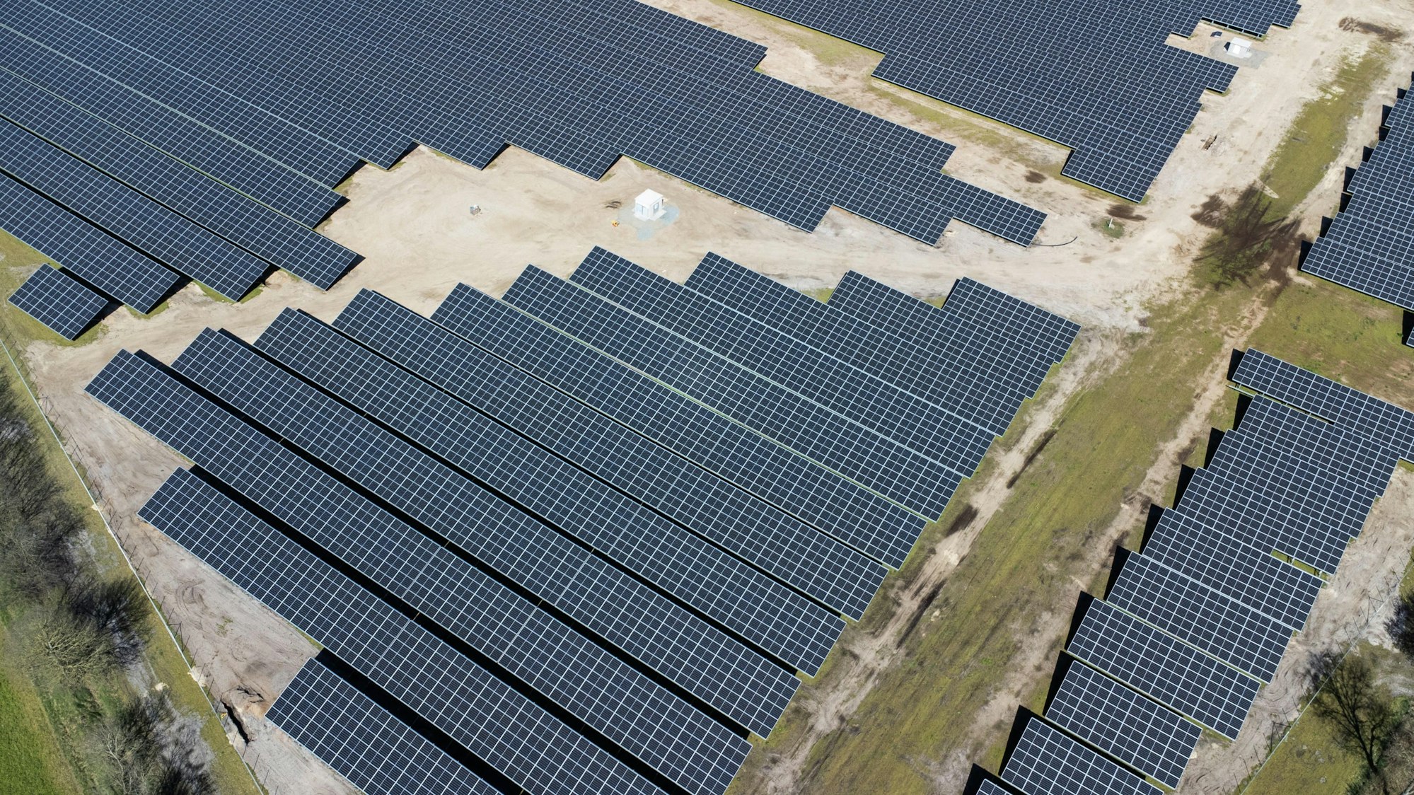 Eine neue Solaranlage steht neben Feldern und einer Autobahn.