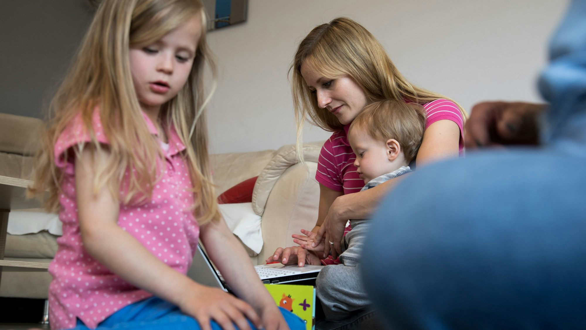 Gleichzeitig am Laptop arbeiten und die Kinder betreuen: Mütter übernehmen trotz Berufstätigkeit deutlich mehr Arbeit im Haushalt.