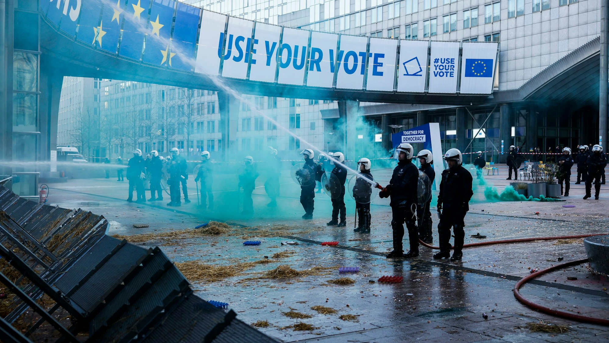 Beamte der Bereitschaftspolizei setzen einen Schlauch ein, um Brände zu löschen, die von Landwirten während einer Demonstration vor dem Europäischen Parlament gelegt wurden. (Archivbild)