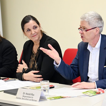 Dr. Sibylle Scharkus und Dr. Harald Rau sitzen an einem Tisch und diskutieren.