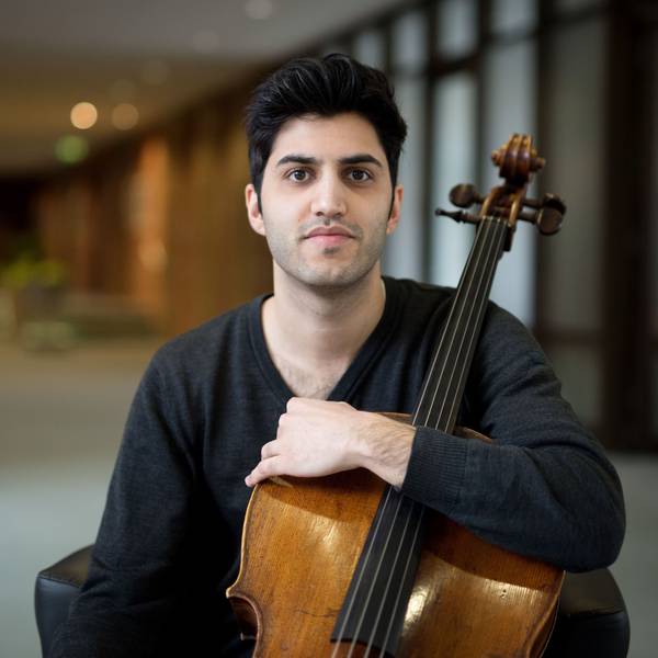Der österreichisch-iranische Cellist Kian Soltani blickt in die Kamera. Er hält sein Cello mit einem