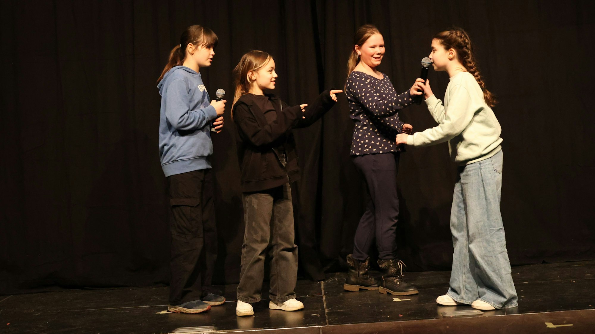 Jugendliche stehen auf der Megafon-Bühne mit Mikrofonen in der Hand.
