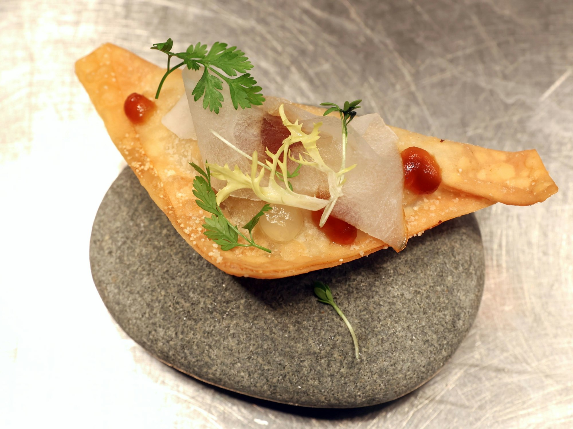 Eine kleine Teigtasche auf einem Stein serviert.