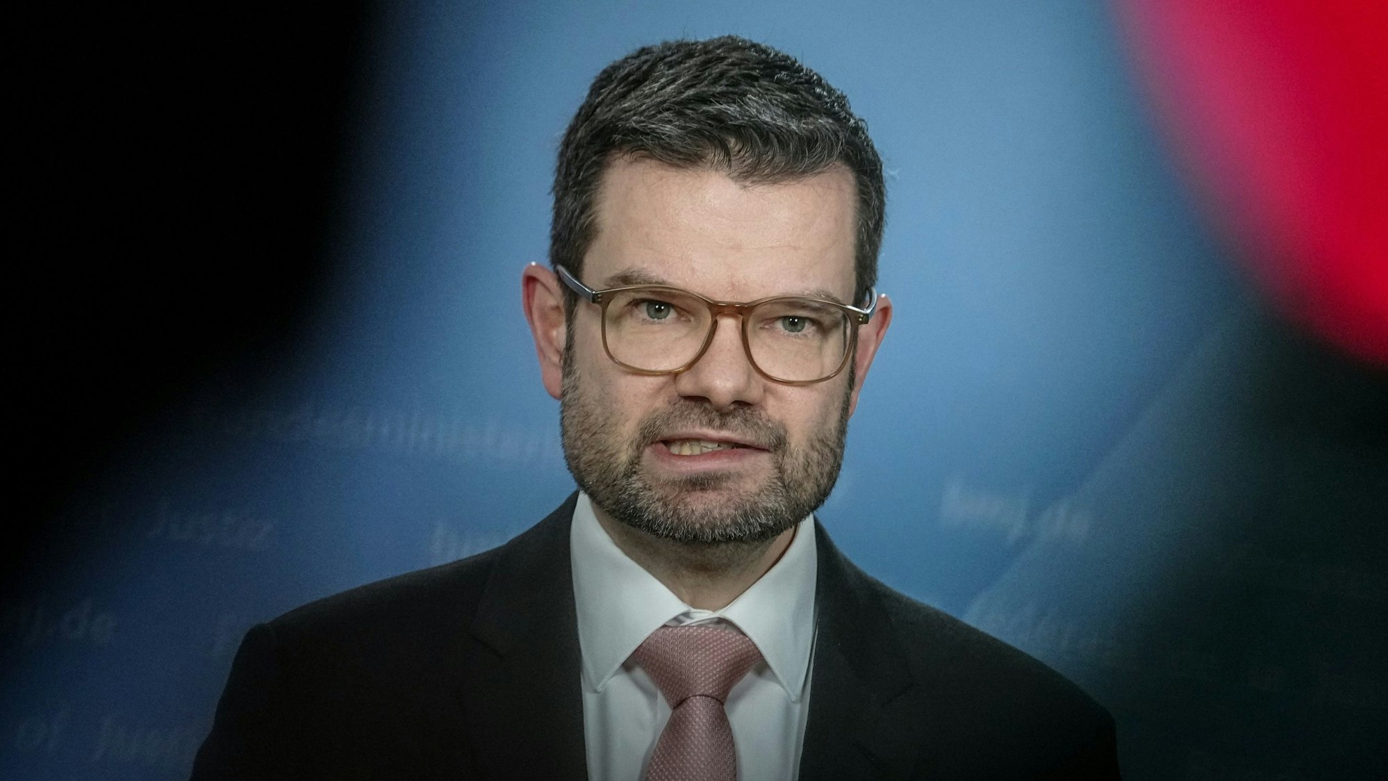 Bundesjustizminister Marco Buschmann (FDP) steht während einer Pressekonferenz in Berlin auf einer Bühne und blickt ins Publikum.