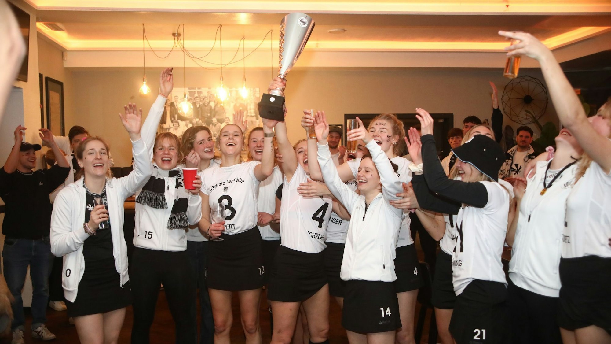 Die Hockey-Damen von Schwarz-Weiß Köln feiern den Aufstieg in die Hallen-Bundesliga ausgelassen in ihrem Klubheim.