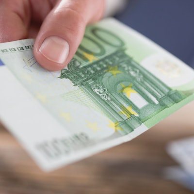 Eine Person hält einen 100-Euro-Schein in der Hand