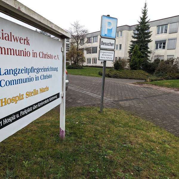 Neben einem Schild des Sozialwerks Communio in Christo e.V. in Mechernich ist das Pflegeheim zu sehen, das der Verein dort betreibt.