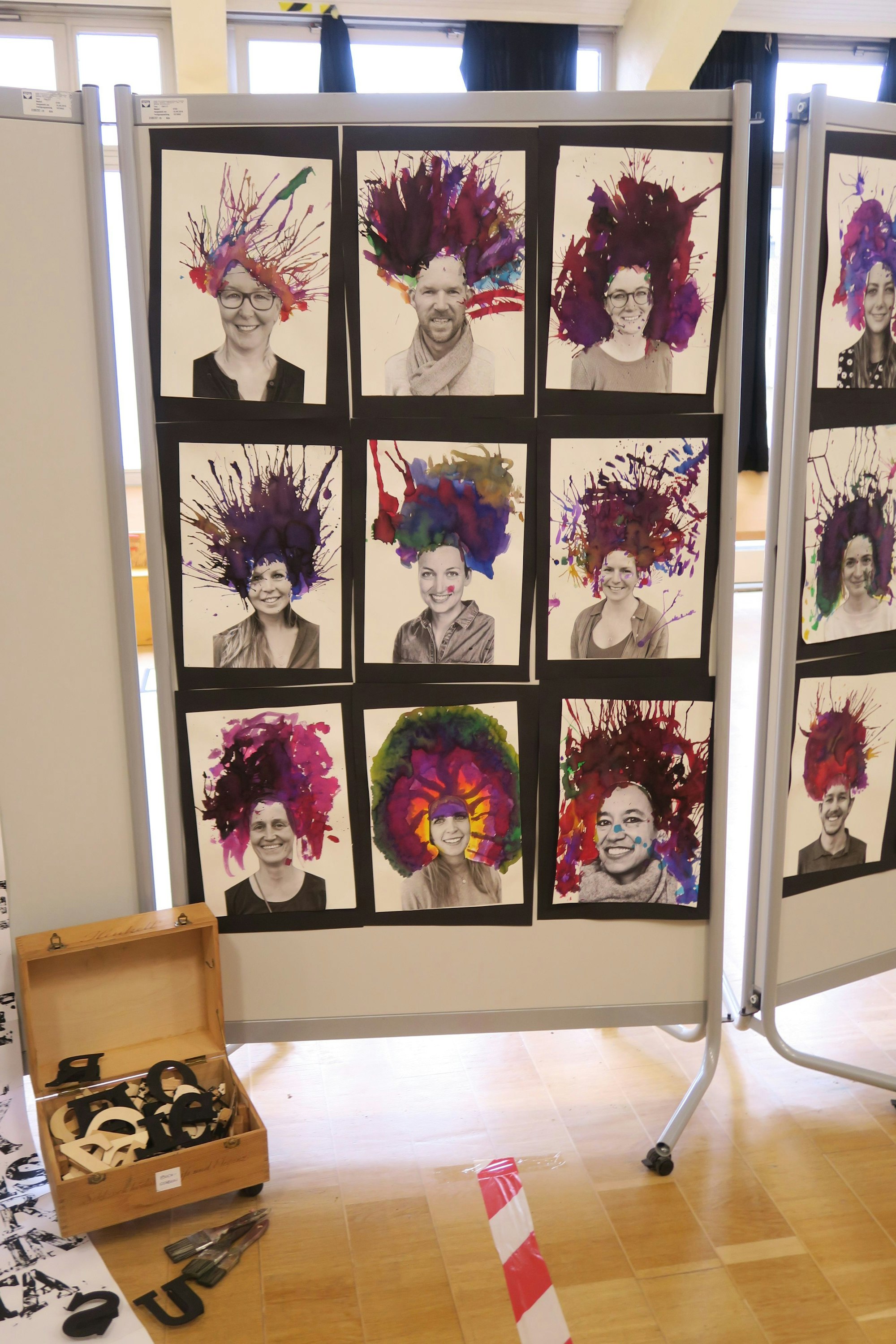 Auf einem Aufsteller sind viele Bilder von Menschen mit irren Frisuren zu sehen.