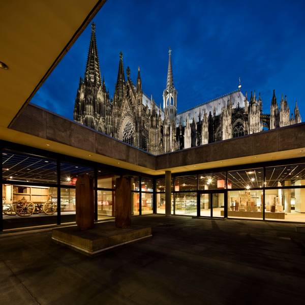 Über dem Atrium des Kölner Römisch-Germanischen Museums erhebt sich der angestrahlte Dom.
