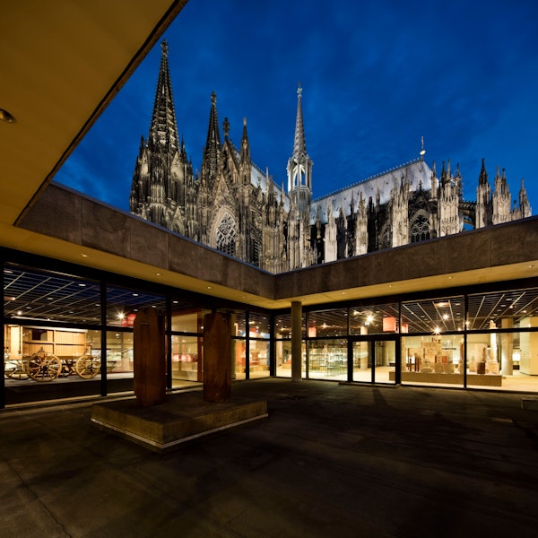 Über dem Atrium des Kölner Römisch-Germanischen Museums erhebt sich der angestrahlte Dom.