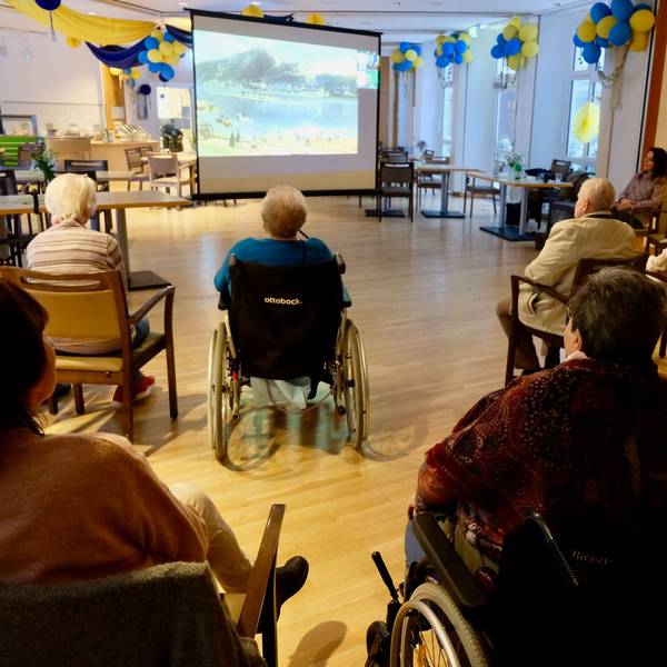 Seniorinnen und Senioren hören einem Vortrag zu.