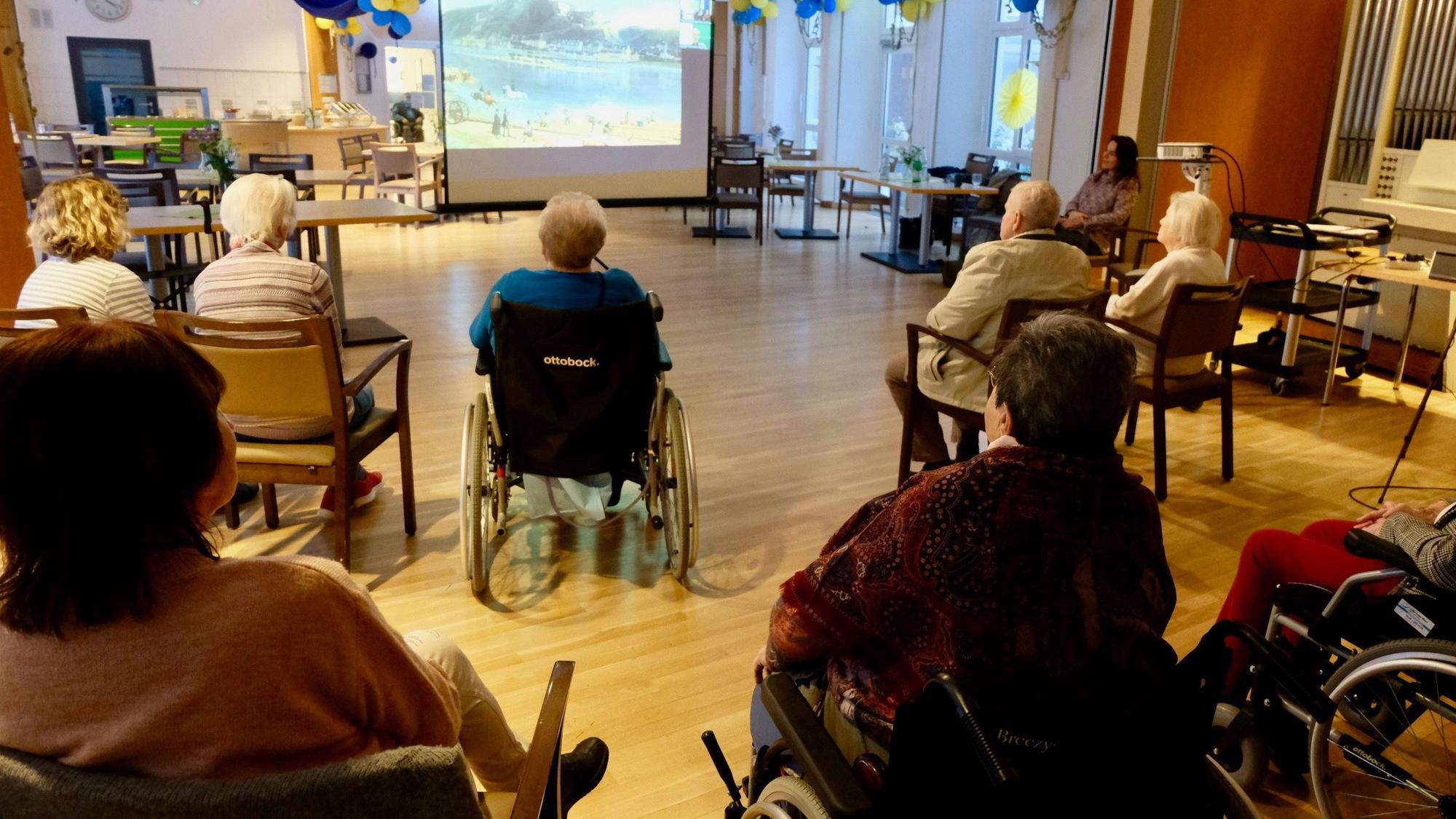 Seniorinnen und Senioren hören einem Vortrag zu.