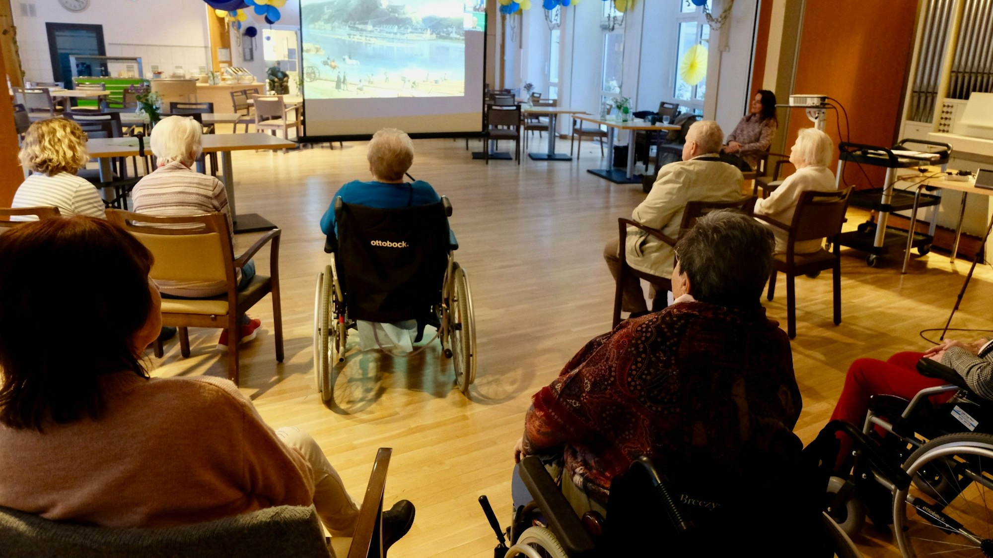 Seniorinnen und Senioren hören einem Vortrag zu.