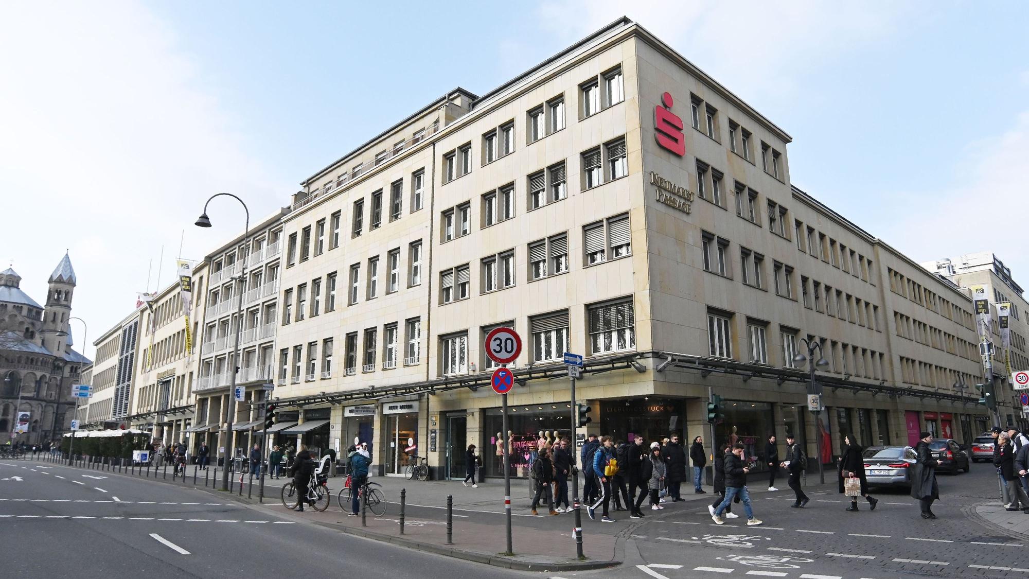 Das Foto zeigt die Neumarkt-Passage, im Hintergrund ist die Kirche St. Aposteln zu sehen.