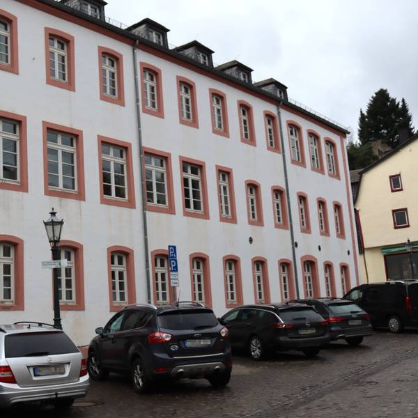 Eine Außenansicht der Grundschule Bad Münstereifel, vor der Autos parken.