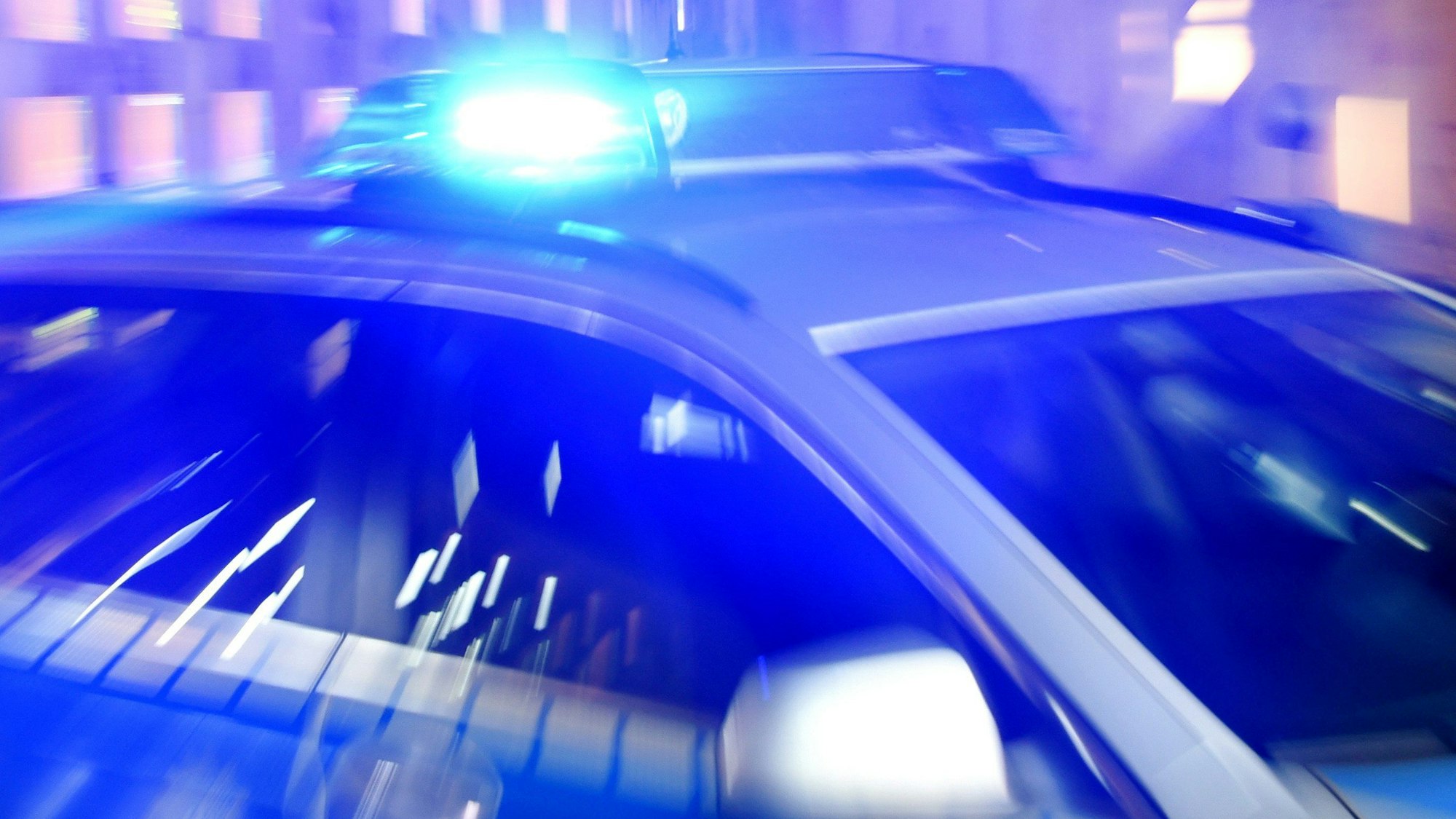 ARCHIV - 06.08.2015, Schleswig-Holstein, Flensburg: Ein Streifenwagen der Polizei steht mit eingeschaltetem Blaulicht auf der Straße. Ein Schmuckhändler ist am Dienstagabend im Hamburger Stadtteil Niendorf gegenüber der St. Ansgar Kirche überfallen worden. (zu dpa: «Überfall auf Schmuckhändler in Hamburg-Niendorf - Polizei sucht Täter») Foto: Carsten Rehder/dpa +++ dpa-Bildfunk +++