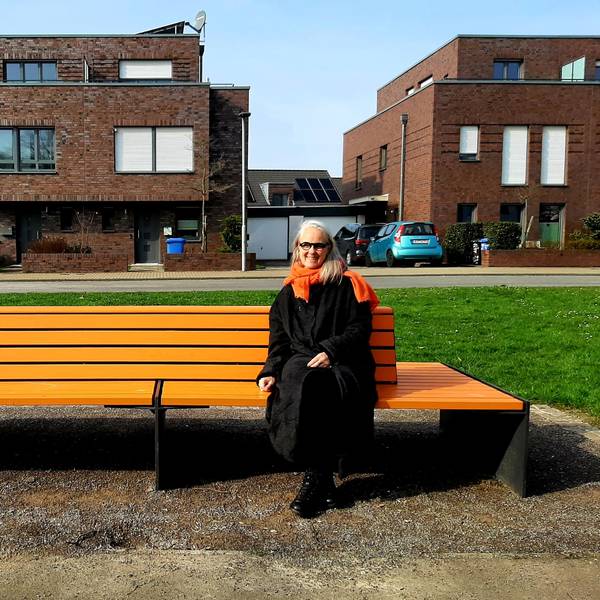 Susanne Wedewer vom Zonta-Club Leverkusen sitzt auf der vom Zonta-Club aufgestellten orangenen Bank in der Neuen Bahnstadt Opladen, auf der sie demnächst regelmäßig (bekannte) Menschen der Stadt zum Thema Frauenrechte, Gleichstellung, Sexismus, Gewalt gegen Frauen befragen will.