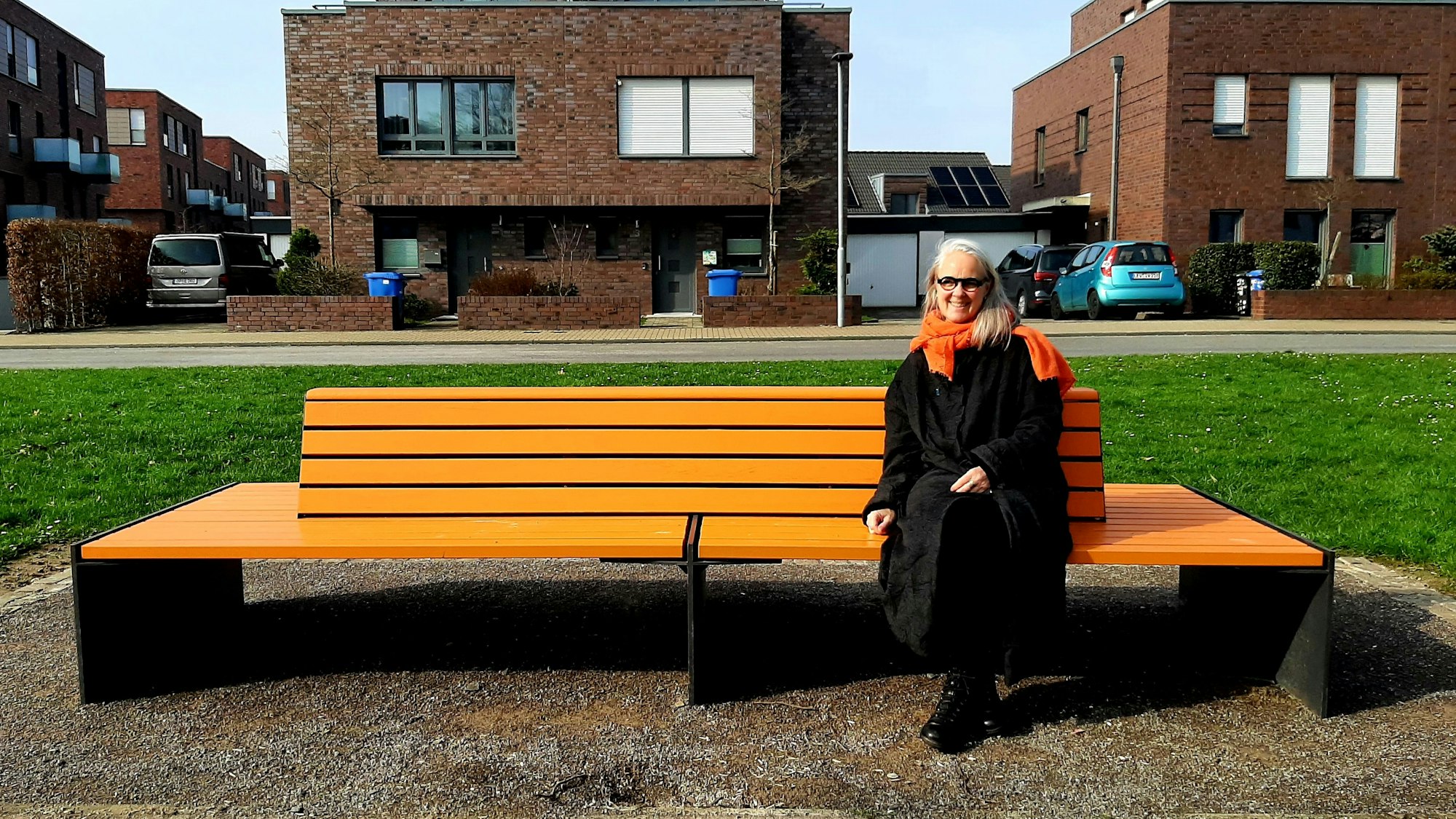 Susanne Wedewer vom Zonta-Club Leverkusen sitzt auf der vom Zonta-Club aufgestellten orangenen Bank in der Neuen Bahnstadt Opladen, auf der sie demnächst regelmäßig (bekannte) Menschen der Stadt zum Thema Frauenrechte, Gleichstellung, Sexismus, Gewalt gegen Frauen befragen will.