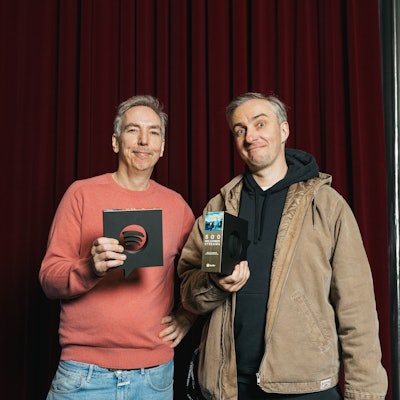 Die beiden halten den Preis in Form des Spotify Logos in die Kamera.