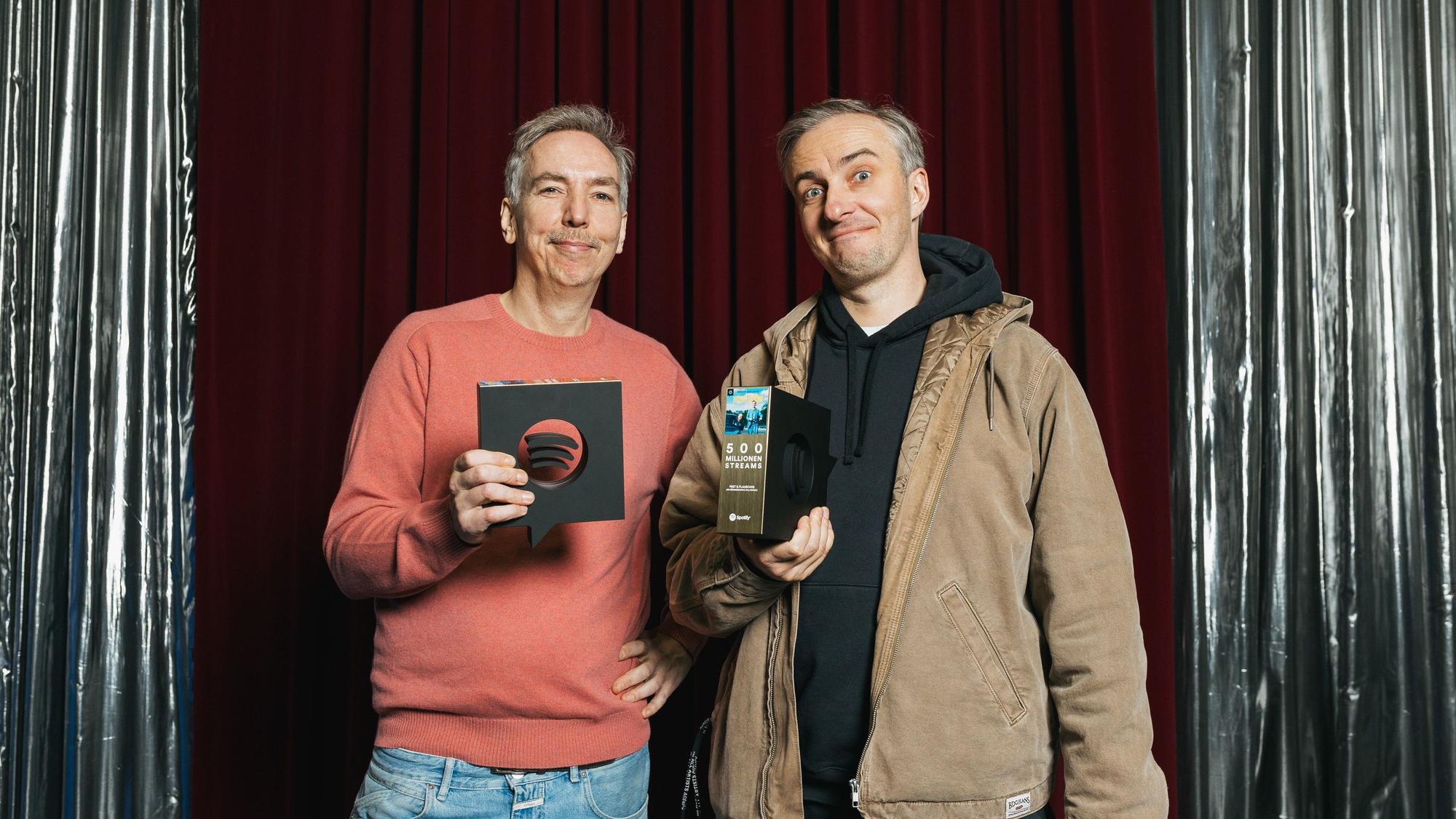 Die beiden halten den Preis in Form des Spotify Logos in die Kamera.