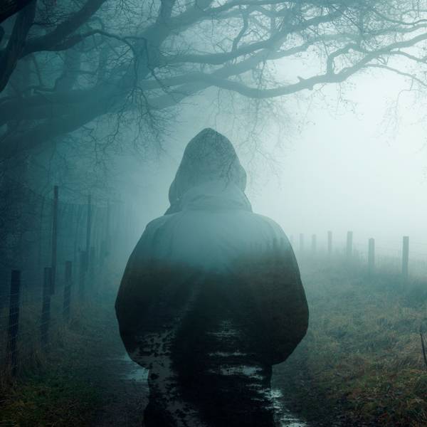 Ein Man steht im Nebel.
