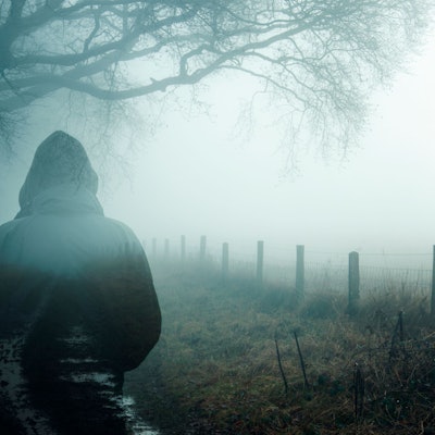 Ein Man steht im Nebel.