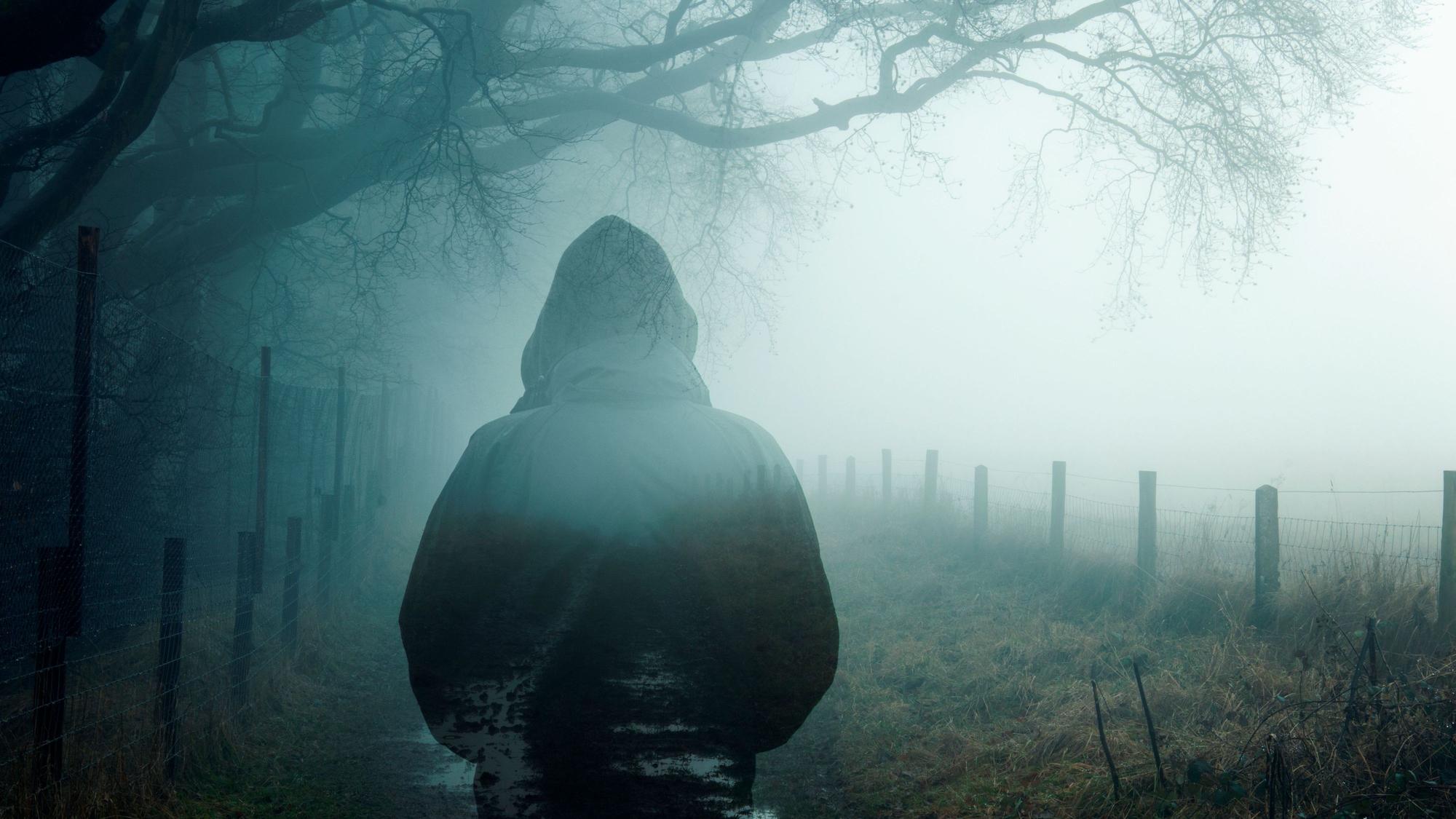 Ein Man steht im Nebel.
