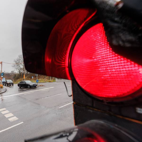 Eine rote Ampel vor einer Einmündung.