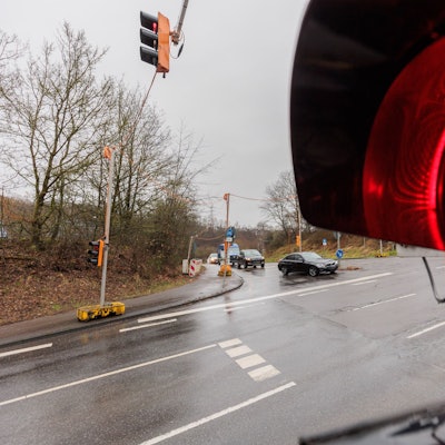Eine rote Ampel vor einer Einmündung.