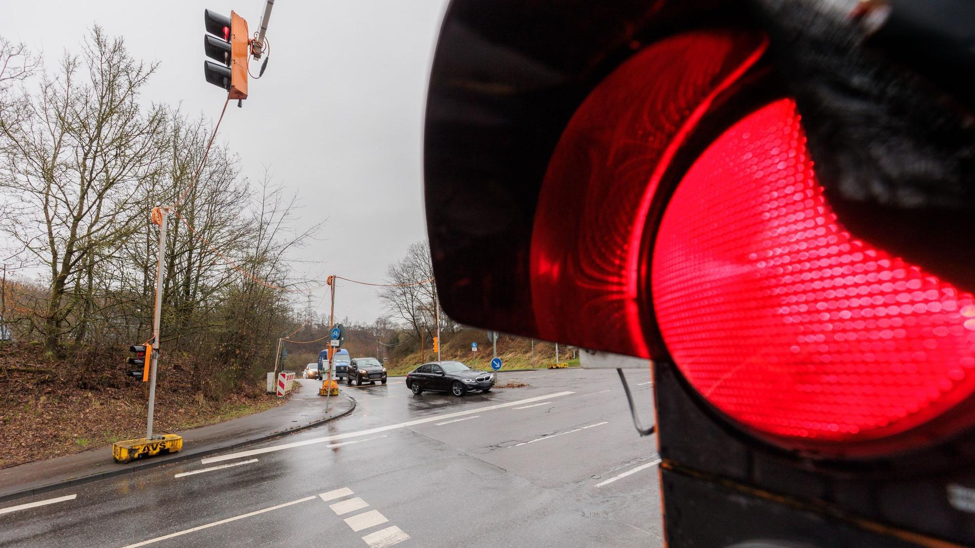 Eine rote Ampel vor einer Einmündung.