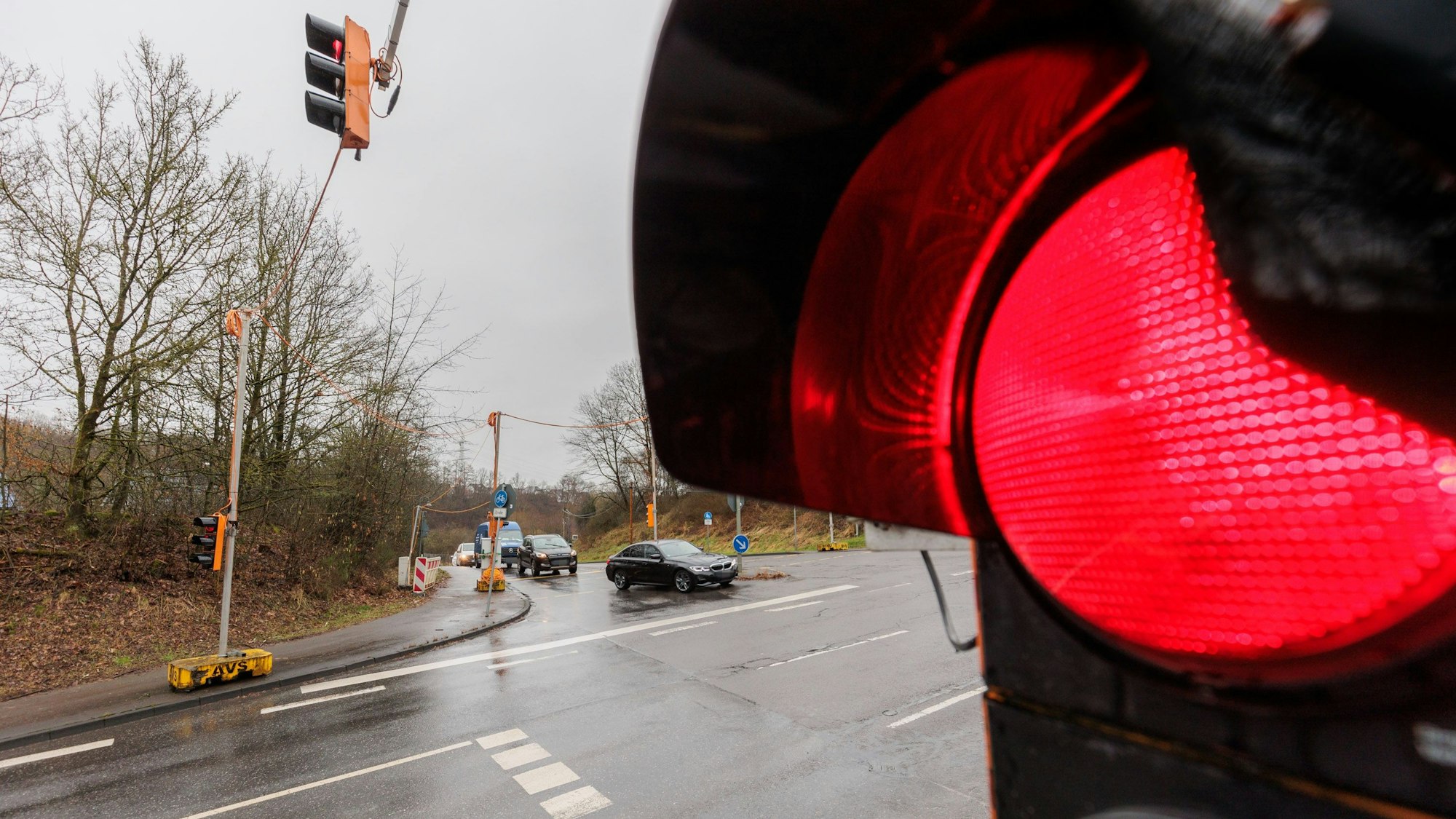 Eine rote Ampel vor einer Einmündung.