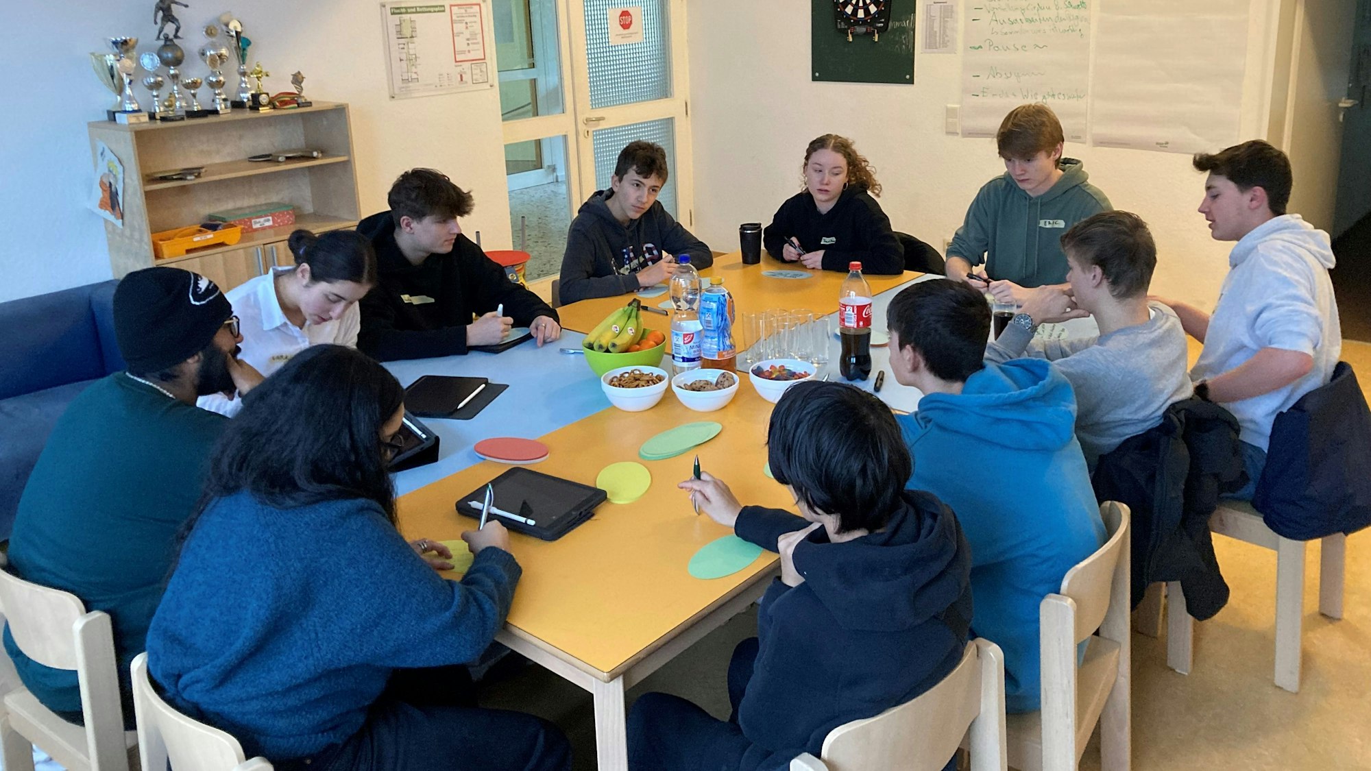 Jugendliche sitzen an einem großen Tisch