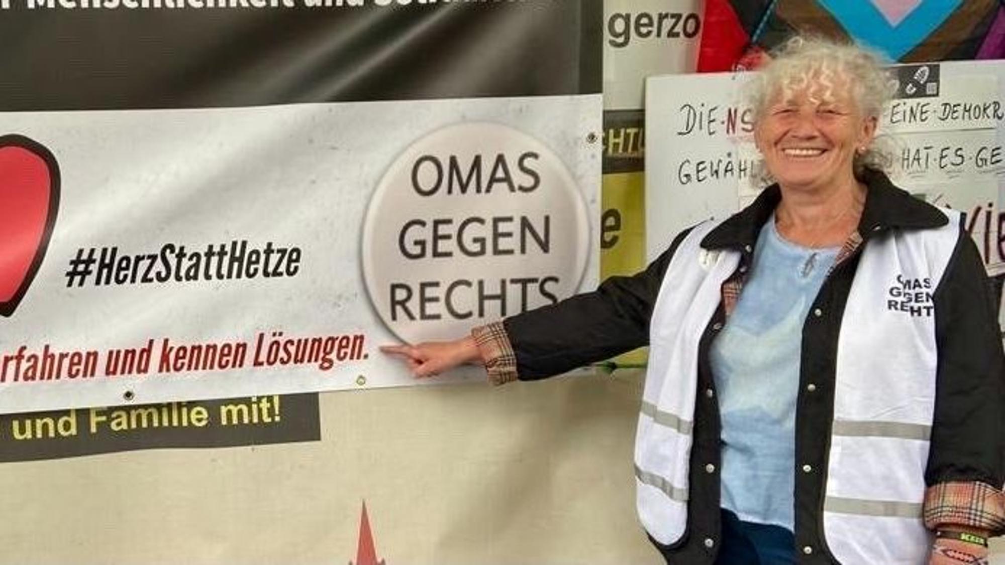 Walli Forner vor einem Plakat der Bürgerinitiative „Omas gegen Rechts“.
