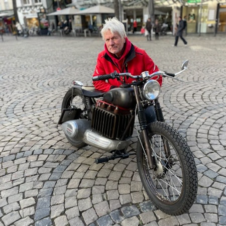 Zu sehen ist ein Mann auf einem Motorrad.