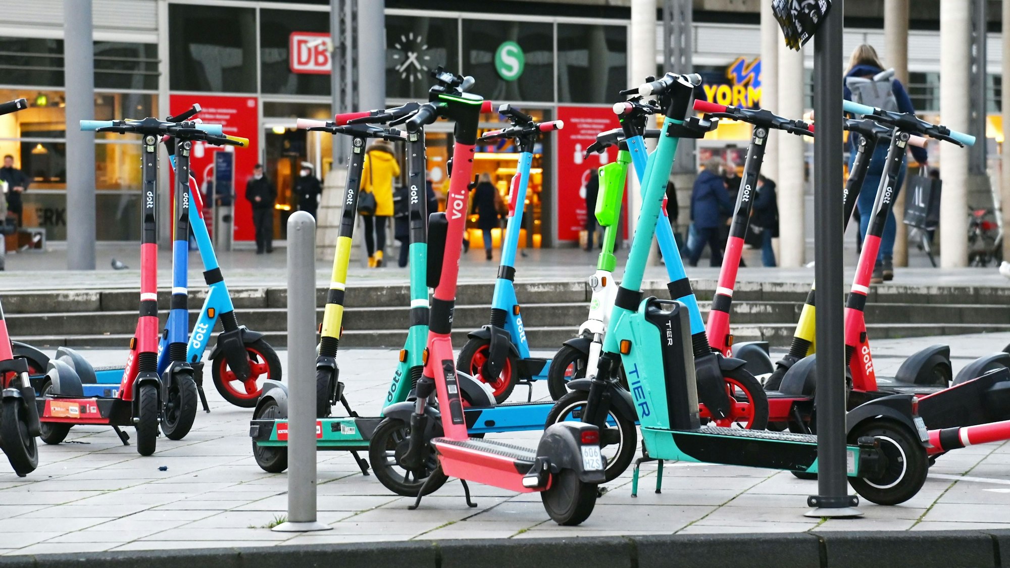 E-Scooter stehen vor dem Kölner Hauptbahnhof auf dem Breslauer Platz: Ab 1. März dürfen sie nicht mehr in öffentlichen Verkehrsmitteln des VRS mitgenommen werden.