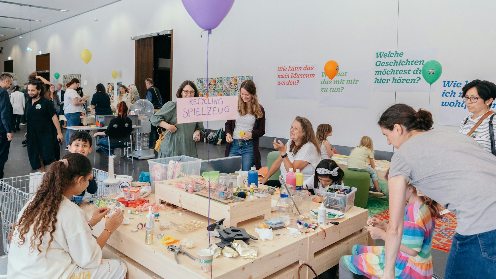 Kinder und Erwachsene, die um einen Basteltisch herumsitzen