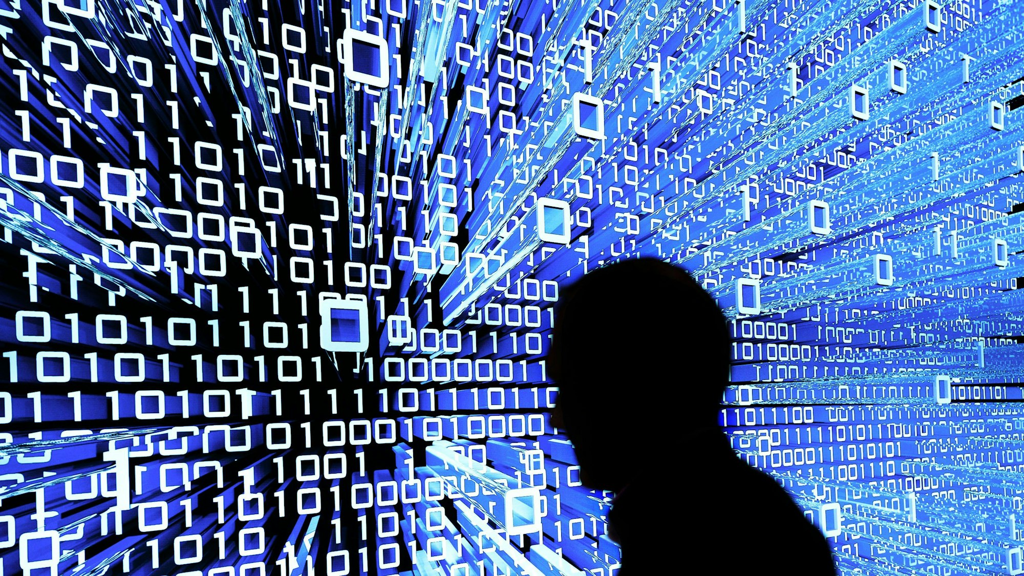 Ein Messebesucher geht an einem Leuchtdisplay auf der CeBIT vorbei.