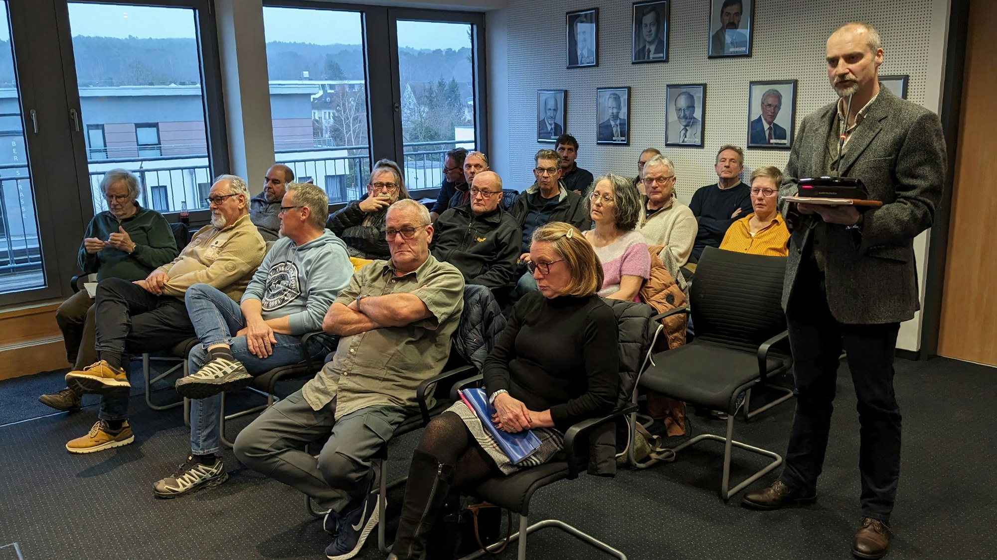 Eine Gruppe Bürger aus Kallmuth sitzt im Sitzungssaal des Mechernicher Rathauses. Ein Mann steht und hält Akten in der Hand.