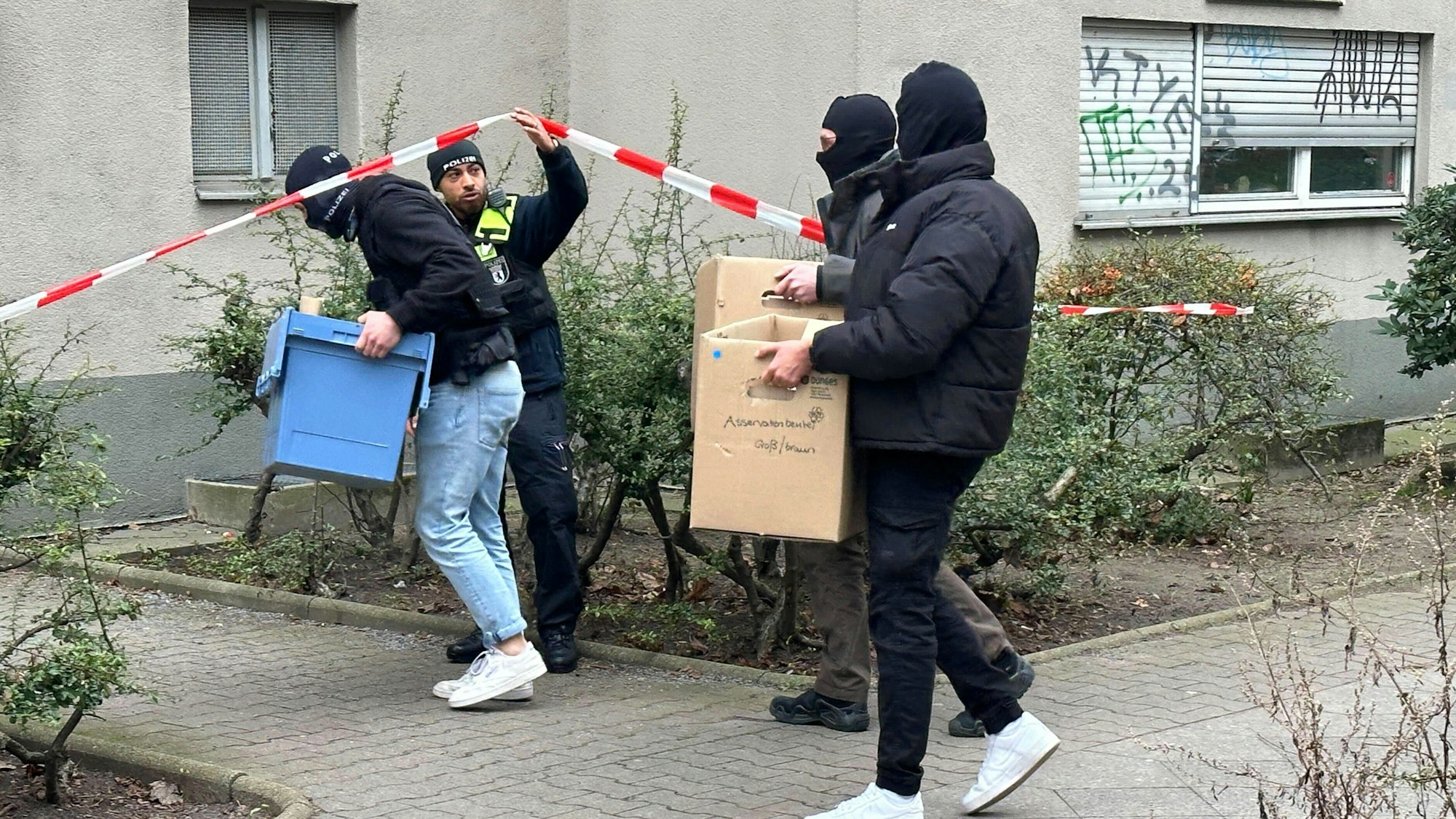 Ermittler gehen mit Kisten und Kartons in das Wohnhaus der früheren RAF-Terroristin Daniela Klette.