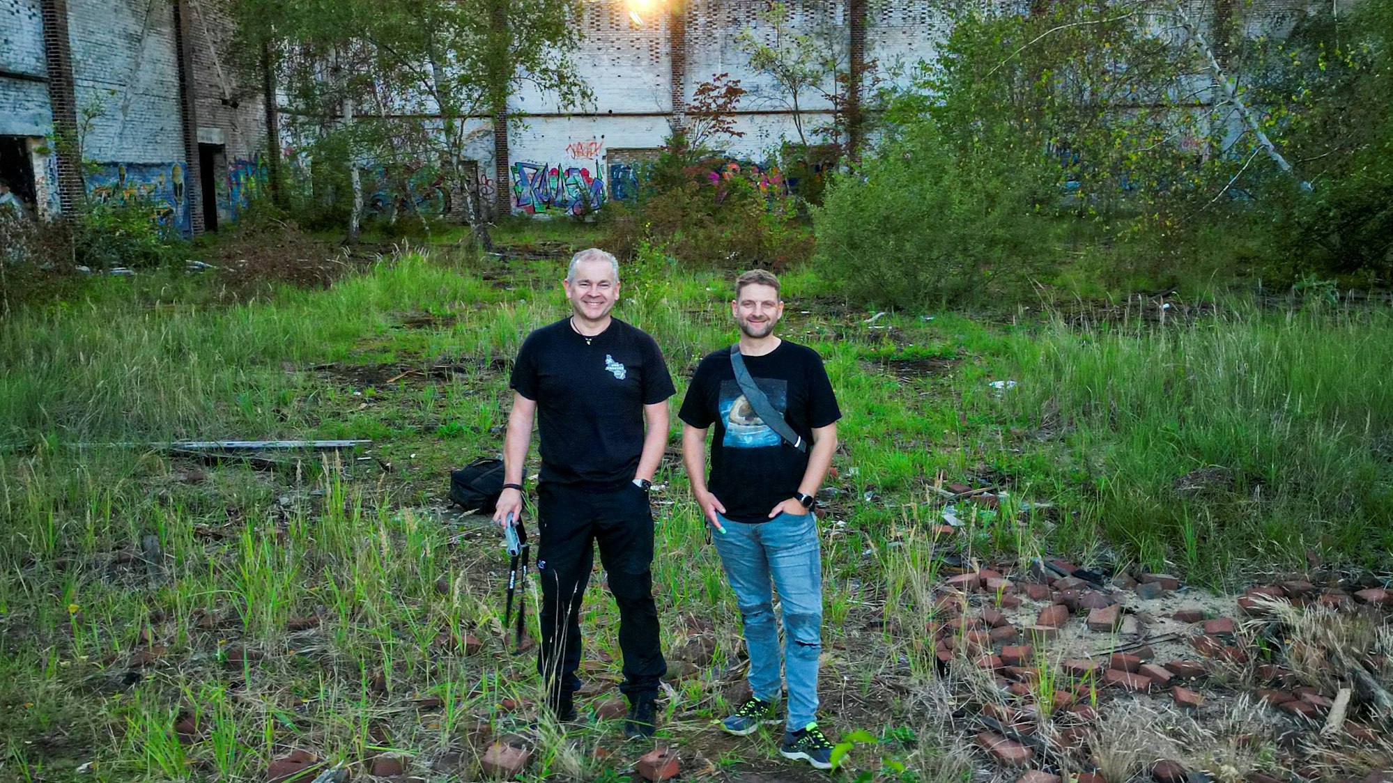 Zwei Männer stehen in einem alten Fabrikgebäude.