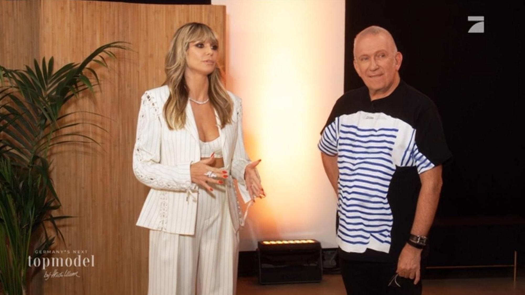 Heidi Klum und Jean-Paul Gaultier stehe nebeneinander und schauen an der Kamera vorbei.