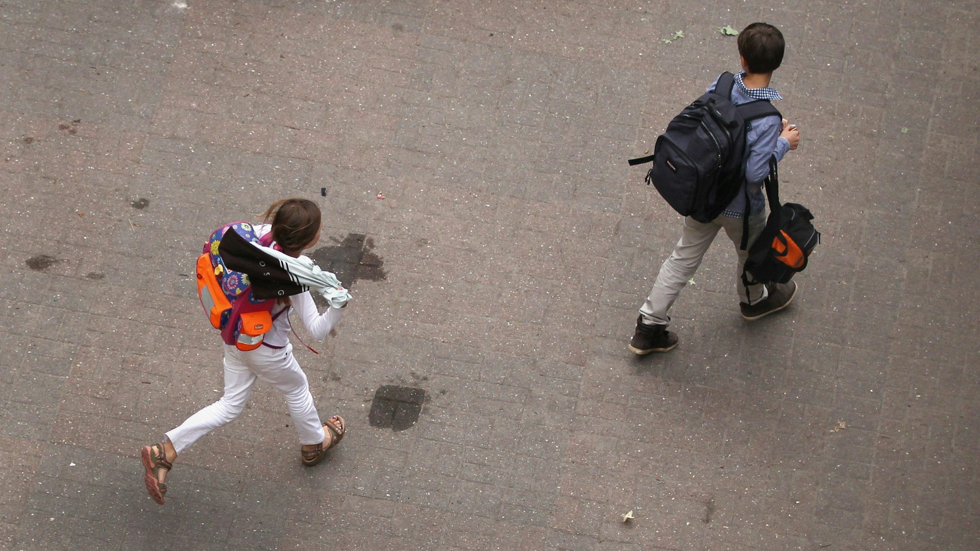 Symbolbild: Zwei Schüler gehen über den Hof einer Schule.