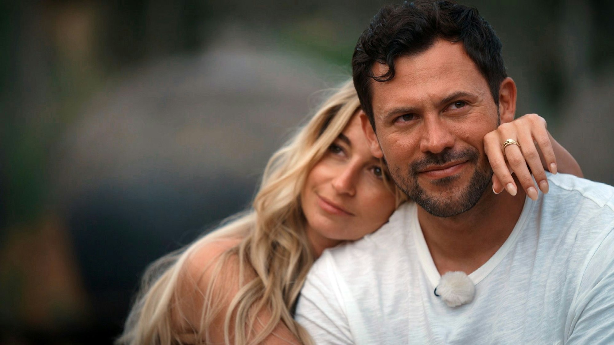 Larissa und Sebastian kuscheln. Larissa hat ihren Arm um Sebastians Schulter gelegt.